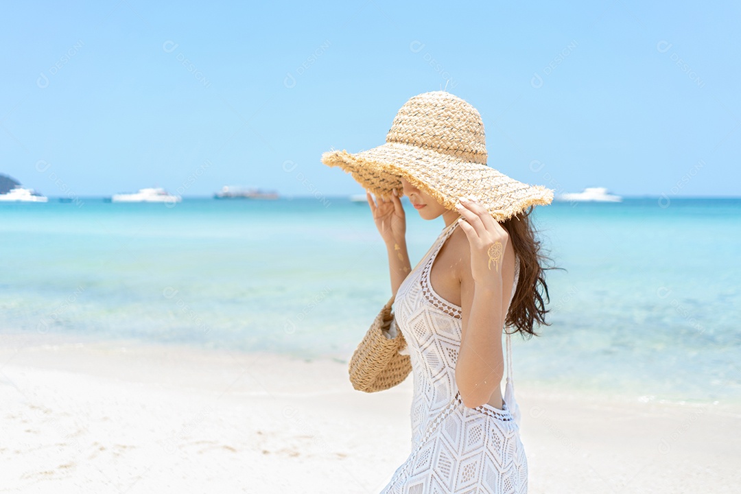 A bela viajante asiática de vestido branco com chapéu.