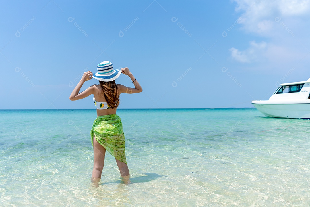 A bela viajante asiática de vestido branco com chapéu.