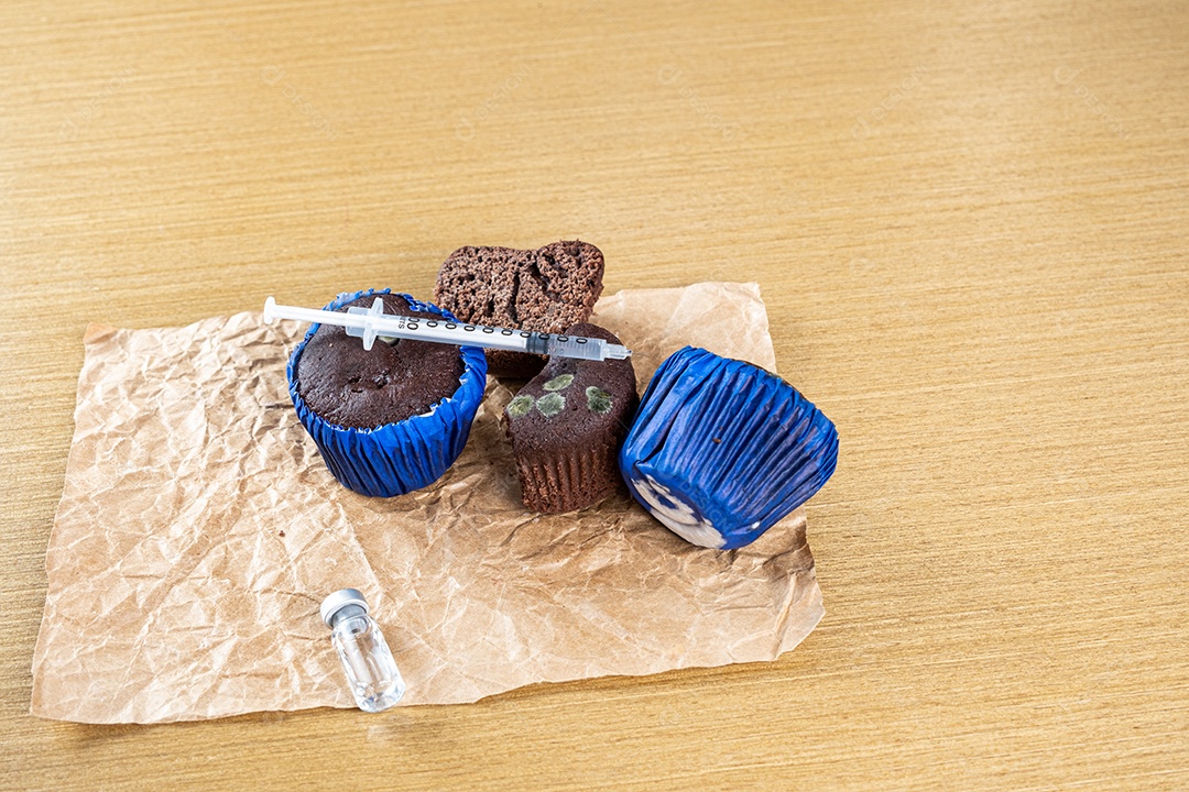 Seringa injetando insulina em bolo de chocolate mofado.