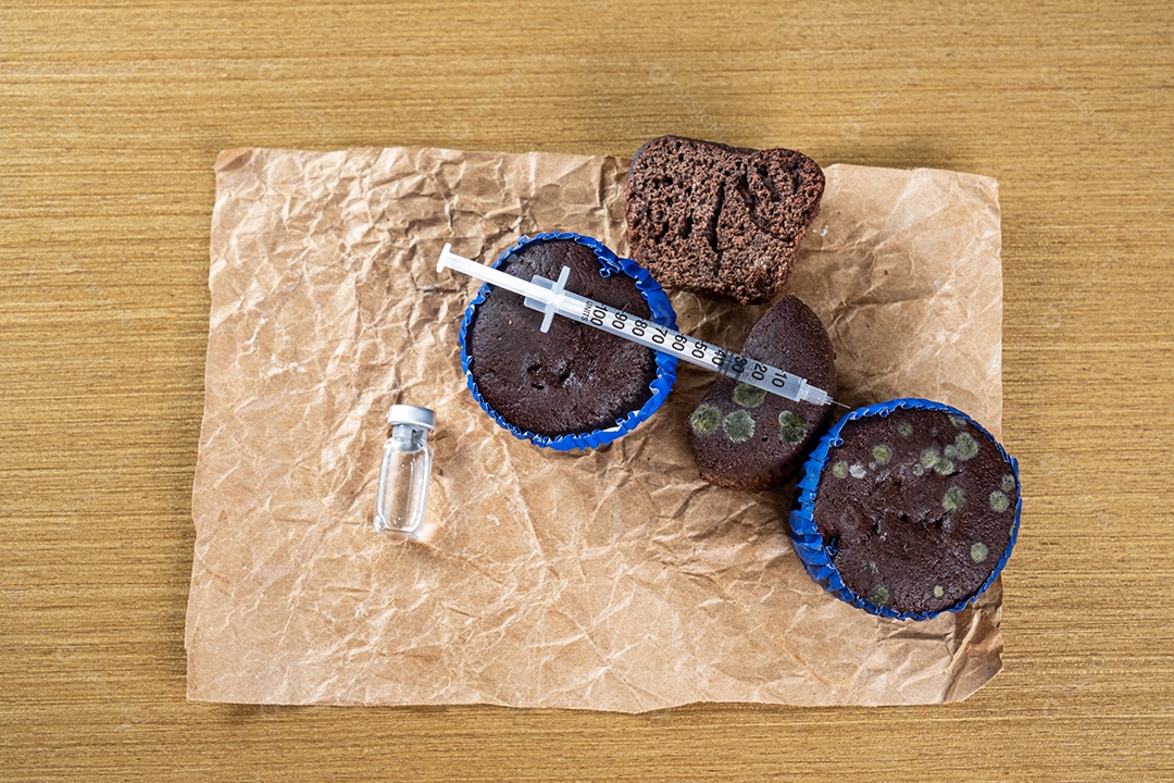 Seringa injetando insulina em bolo de chocolate mofado.