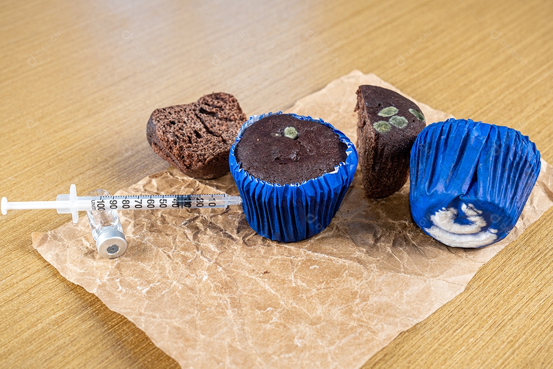 Seringa injetando insulina em bolo de chocolate mofado.