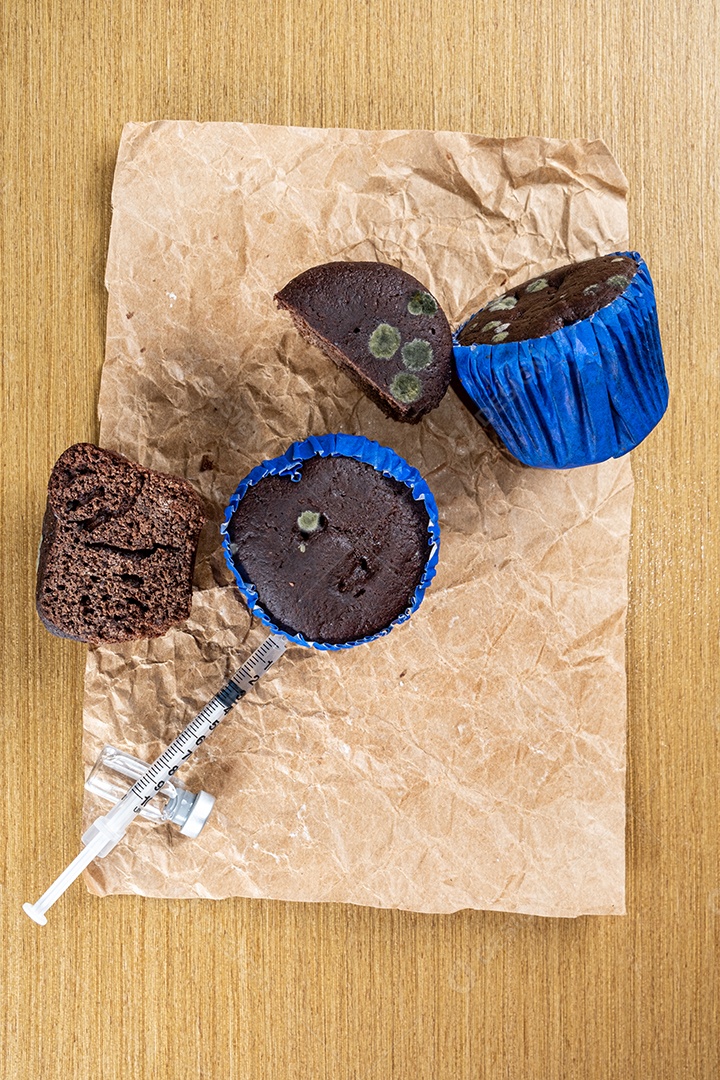 Seringa injetando insulina em bolo de chocolate mofado.