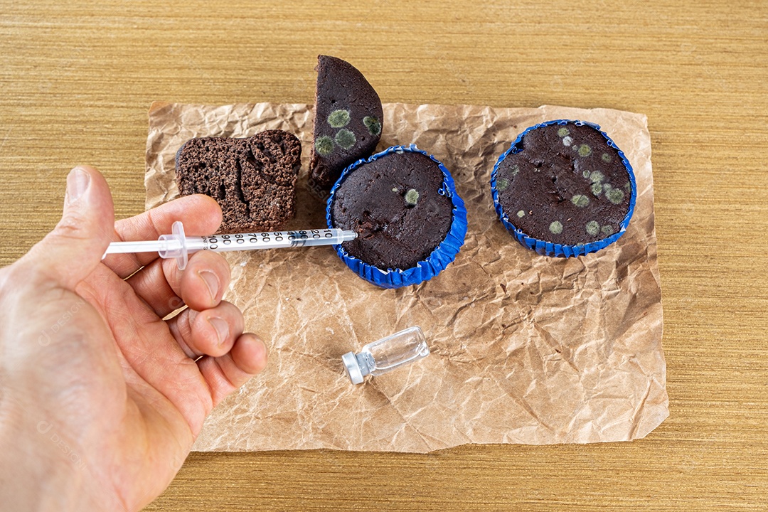 Seringa injetando insulina em bolo de chocolate mofado.