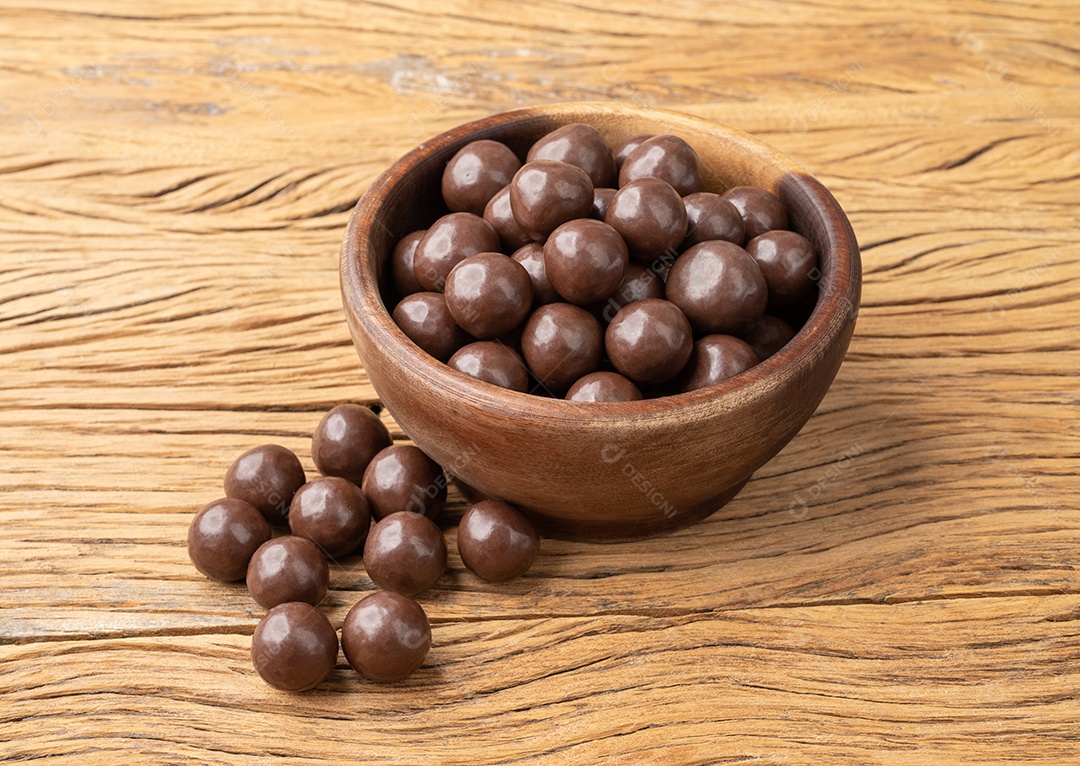 Bolas de chocolate maltadas em uma tigela sobre a mesa de madeira.