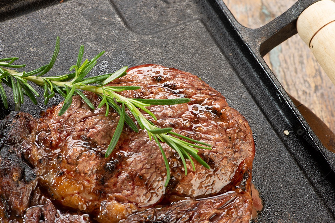 Carne assada sobre uma tabua de madeira alecrim