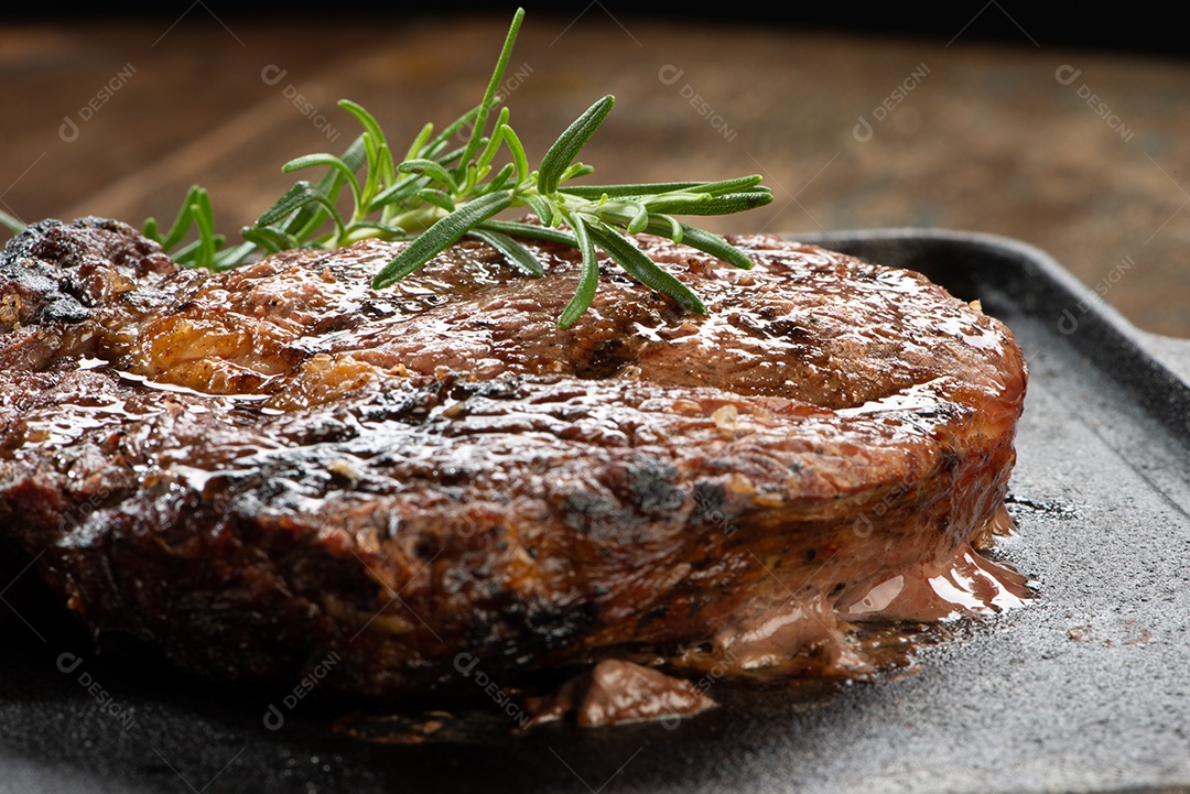 Carne assada sobre uma tabua de madeira alecrim