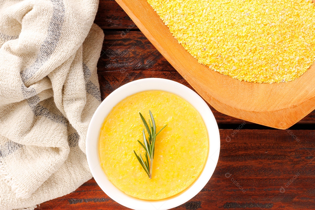 Polenta em tigela de cerâmica na mesa de madeira rústica. Creme de milho