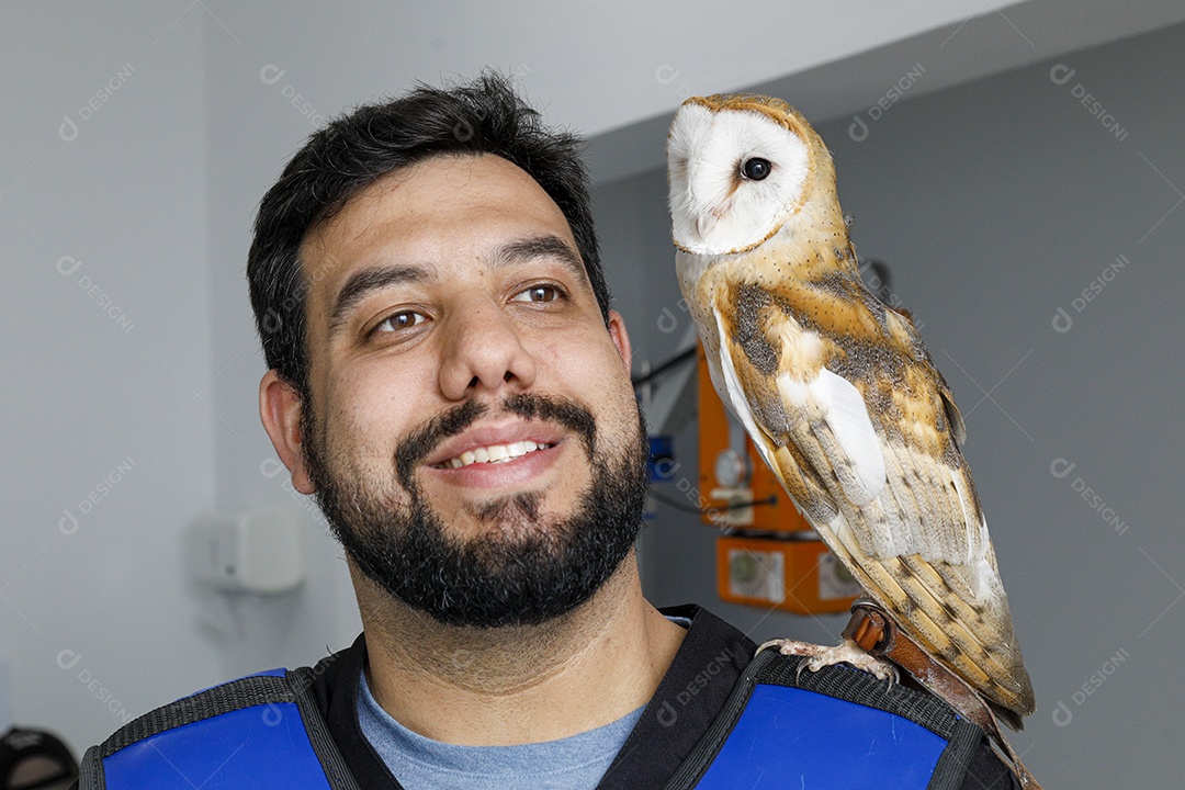 Ave sobre ombro de um homem com seu pássaro estimação