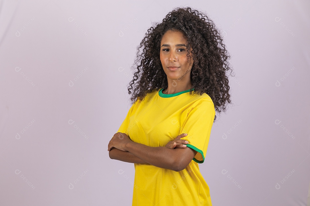 Linda mulher jovem morena torcedora do brasil cabelo afro usando camiseta do brasil sobre fundo isolado