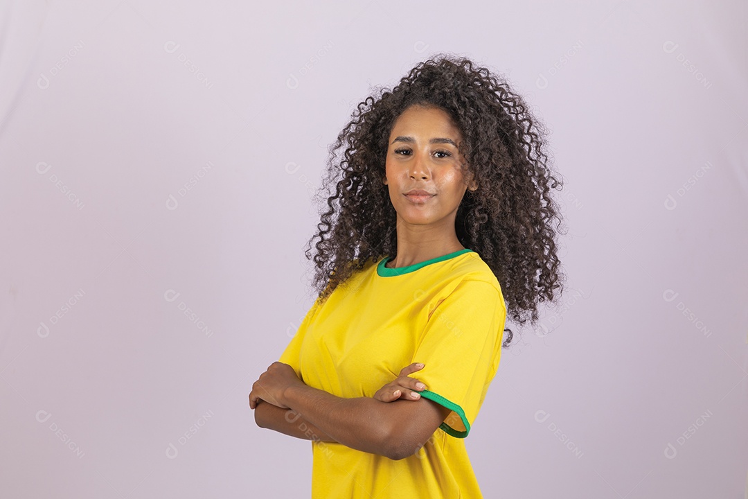 Linda mulher jovem morena torcedora do brasil cabelo afro usando camiseta do brasil sobre fundo isolado