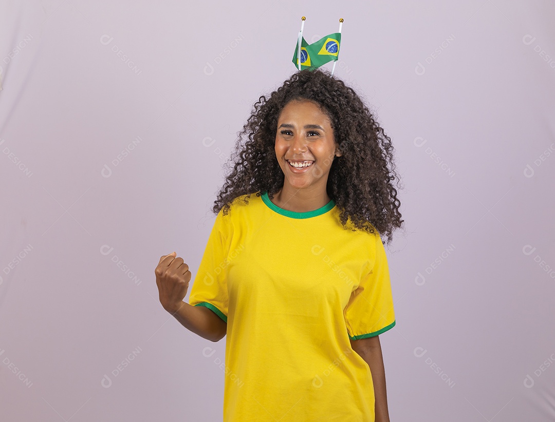 Linda mulher jovem morena torcedora do brasil cabelo afro usando camiseta do brasil sobre fundo isolado