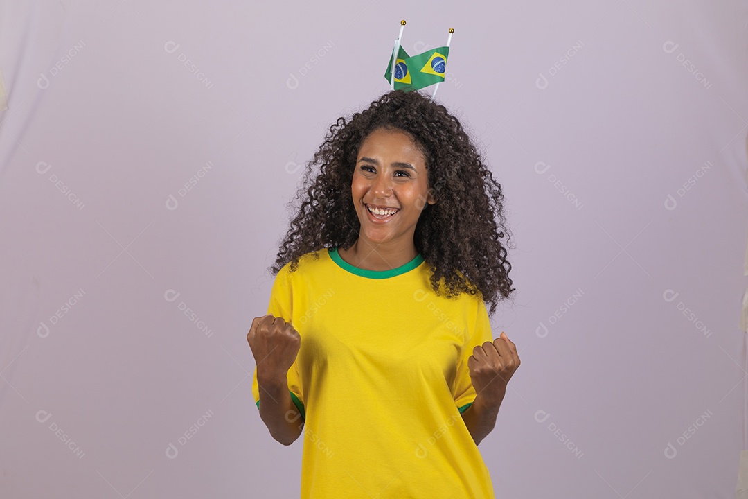 Linda mulher jovem morena torcedora do brasil cabelo afro usando camiseta do brasil sobre fundo isolado