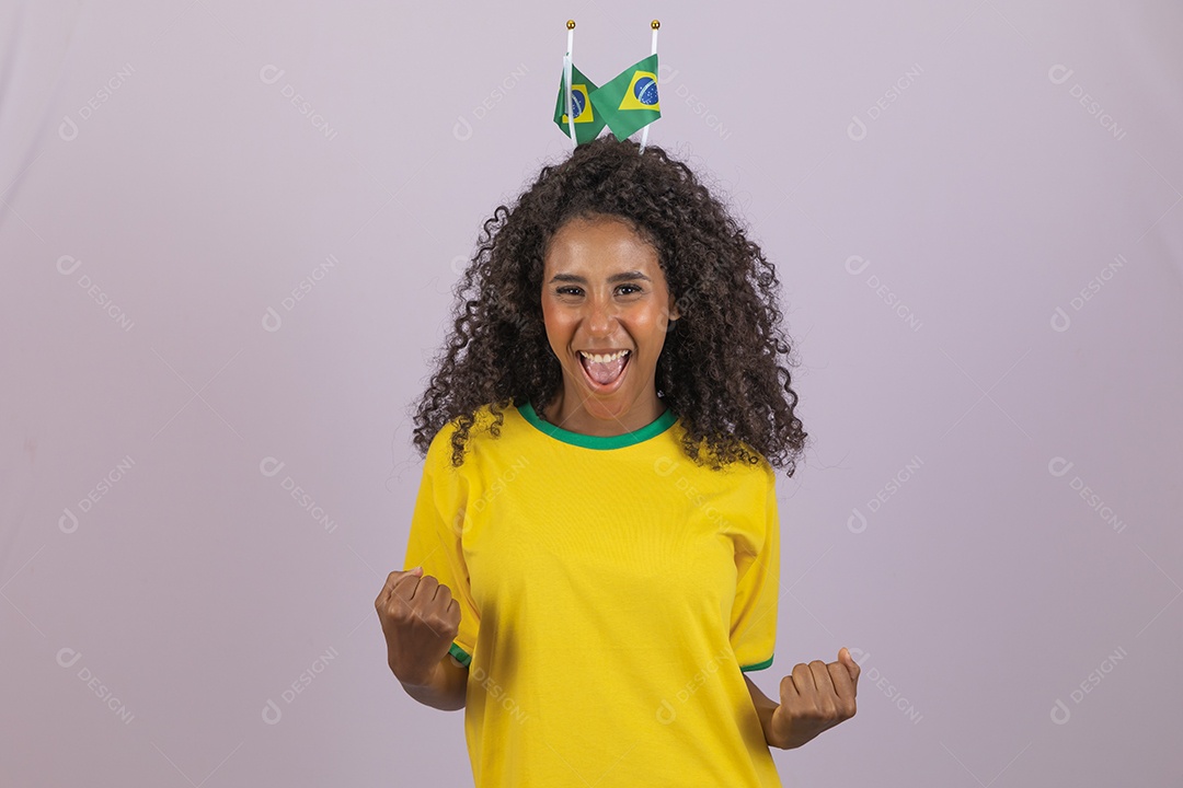 Linda mulher jovem morena torcedora do brasil cabelo afro usando camiseta do brasil sobre fundo isolado