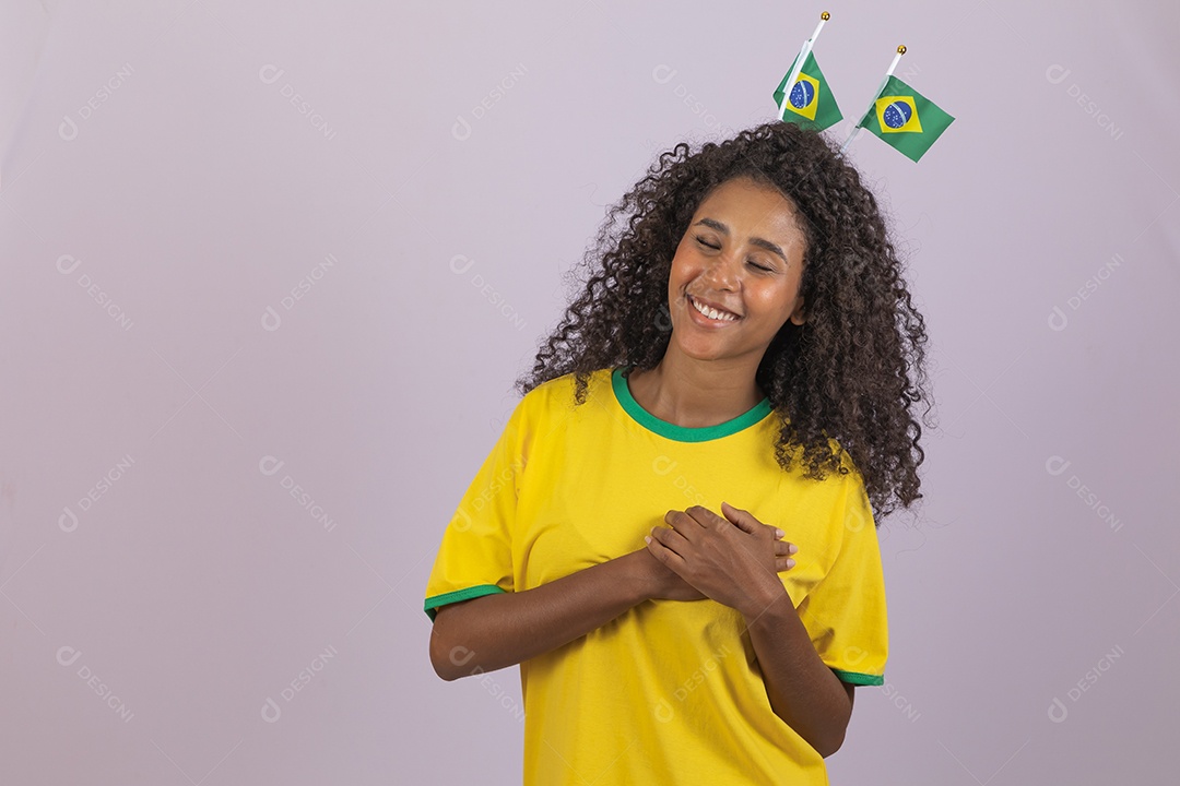 Linda mulher jovem morena torcedora do brasil cabelo afro usando camiseta do brasil sobre fundo isolado