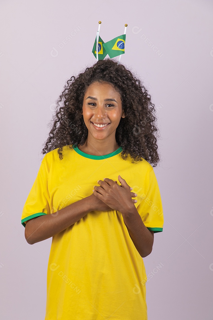 Linda mulher jovem morena torcedora do brasil cabelo afro usando camiseta do brasil sobre fundo isolado
