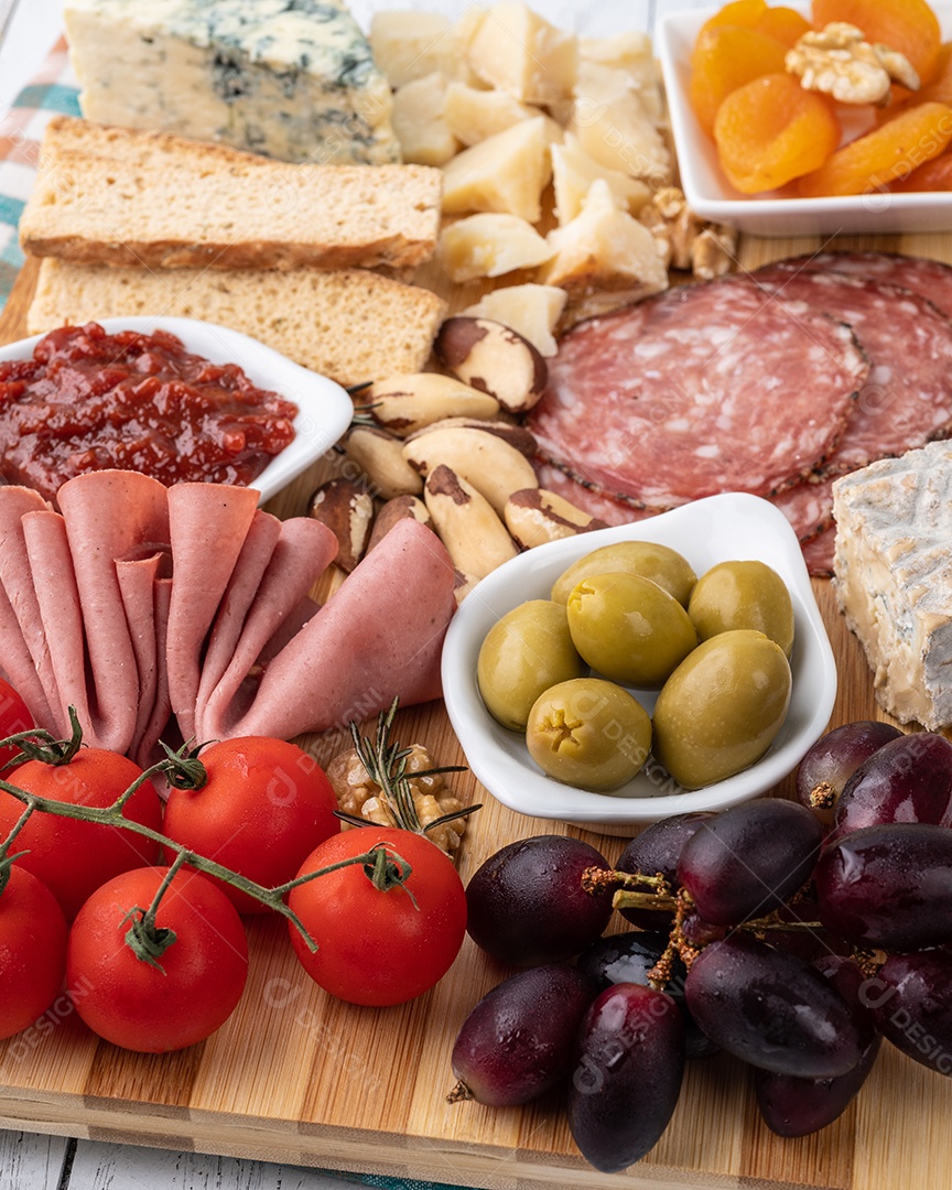 Tábua de aperitivos com queijo, nozes, frutas, torradas e charcutaria