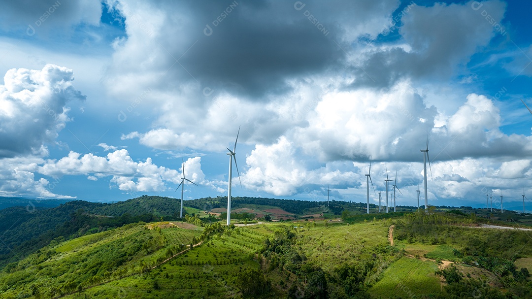Turbina eólica com céu azul e fundo nublado.