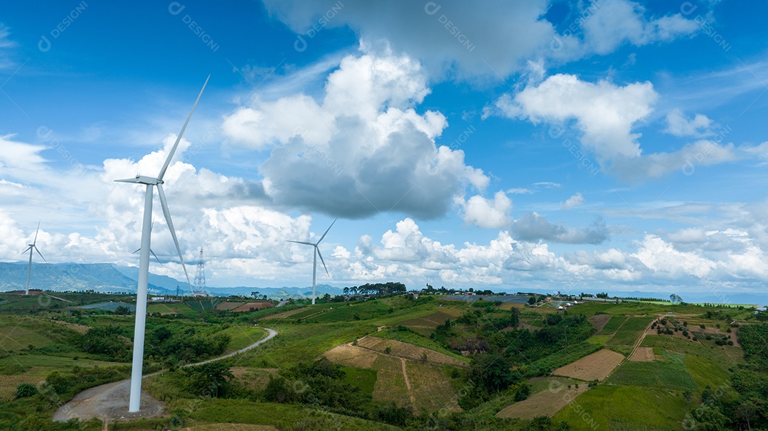 Turbina eólica com céu azul e fundo nublado.