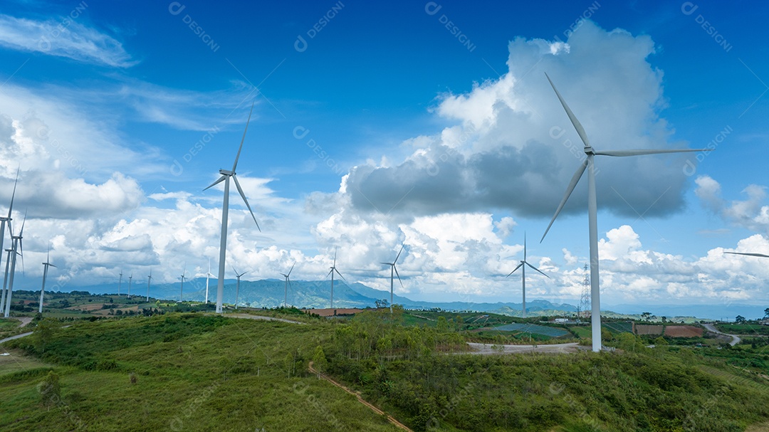 Turbina eólica com céu azul e fundo nublado.