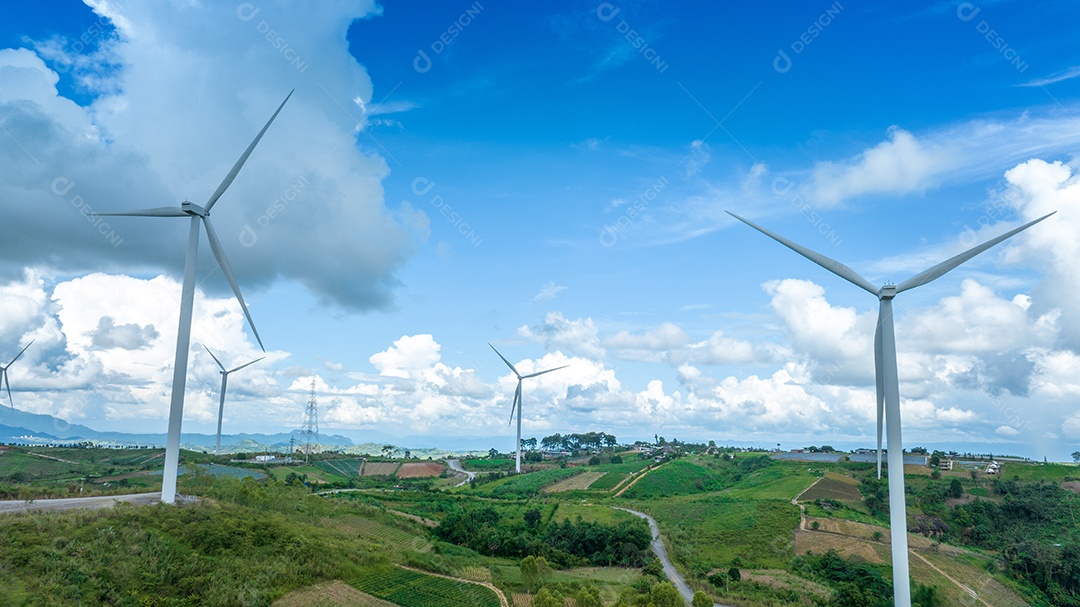Turbina eólica com céu azul e fundo nublado.