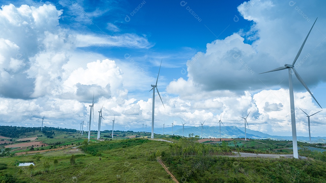 Turbina eólica com céu azul e fundo nublado.