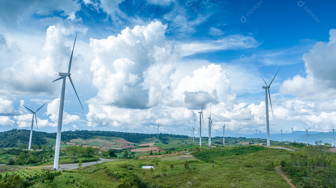 Turbina eólica com céu azul e fundo nublado.