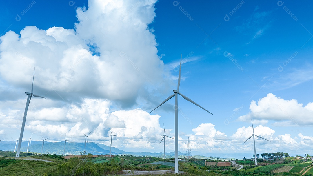 Turbina eólica com céu azul e fundo nublado.