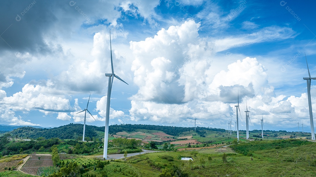 Turbina eólica com céu azul e fundo nublado.