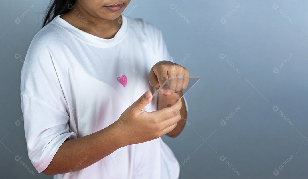 Mulher segurando uma maquete de telefone de tela em branco acrílico transparente.