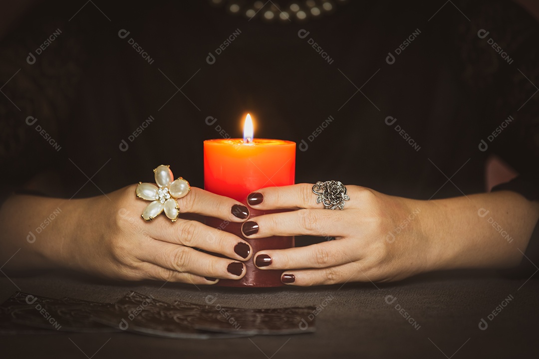 A imagem de uma mulher é uma cartomante, um horóscopo da vida, segurando velas e cartas ciganas nas crenças de olhar para a carreira