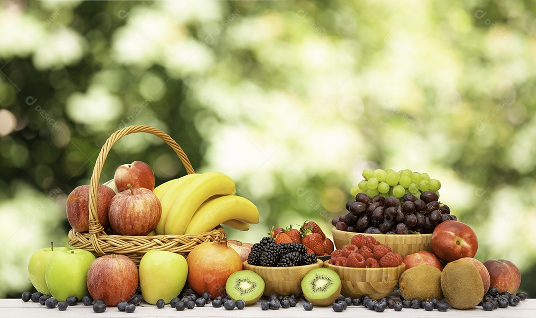 Agrupe frutas frescas saudáveis ​​em uma cesta de madeira, com vitaminas c de bananas, kiwi, uvas, framboesas