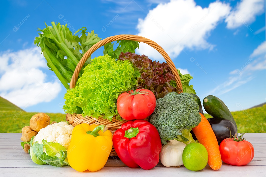 Grupo saudável de vegetais frescos variados em uma cesta de madeira, com vitaminas c de salada, tomate, cenoura, couve-flor e gengibre