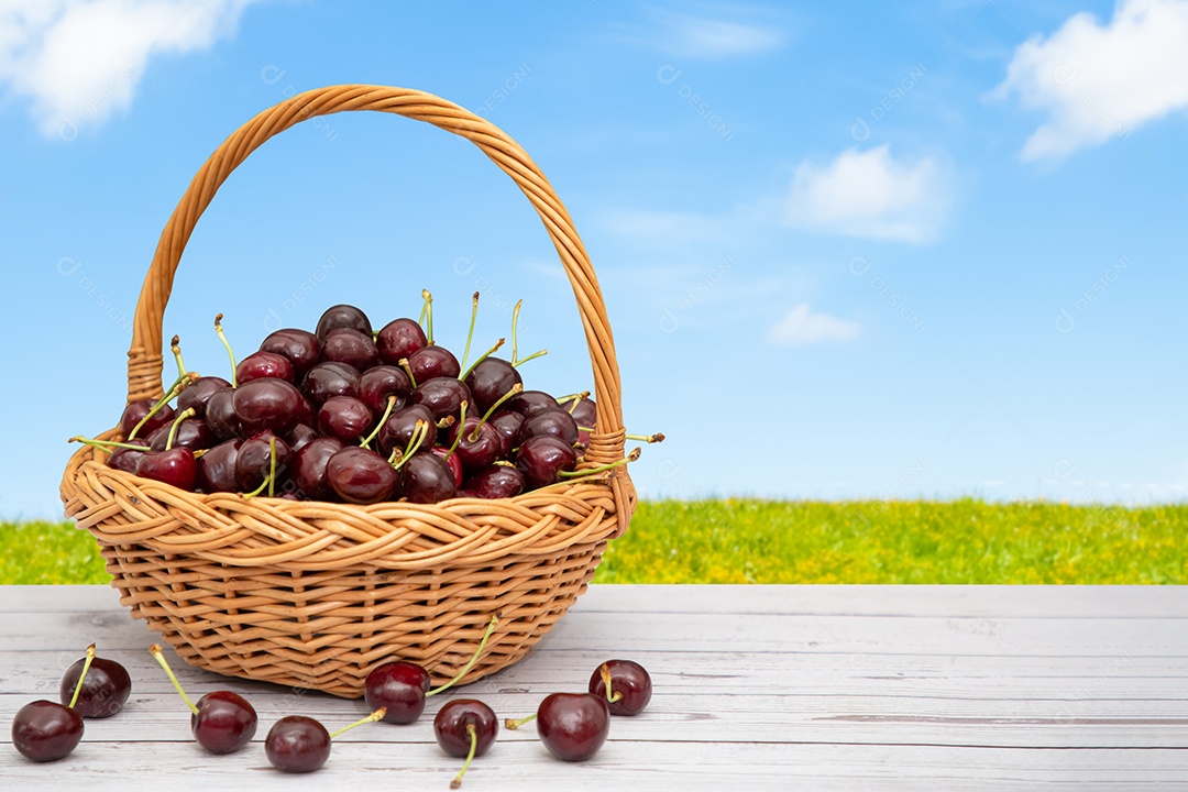 Cereja em uma cesta de madeira sobre uma mesa de madeira em um fundo natural.