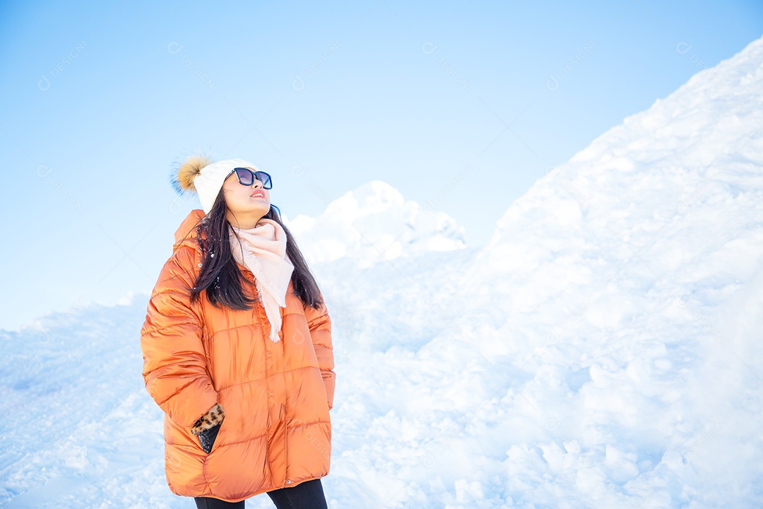 Uma foto de uma linda mulher olhando para uma montanha com muita neve felizmente como férias de férias e curtindo a natureza nas montanhas.