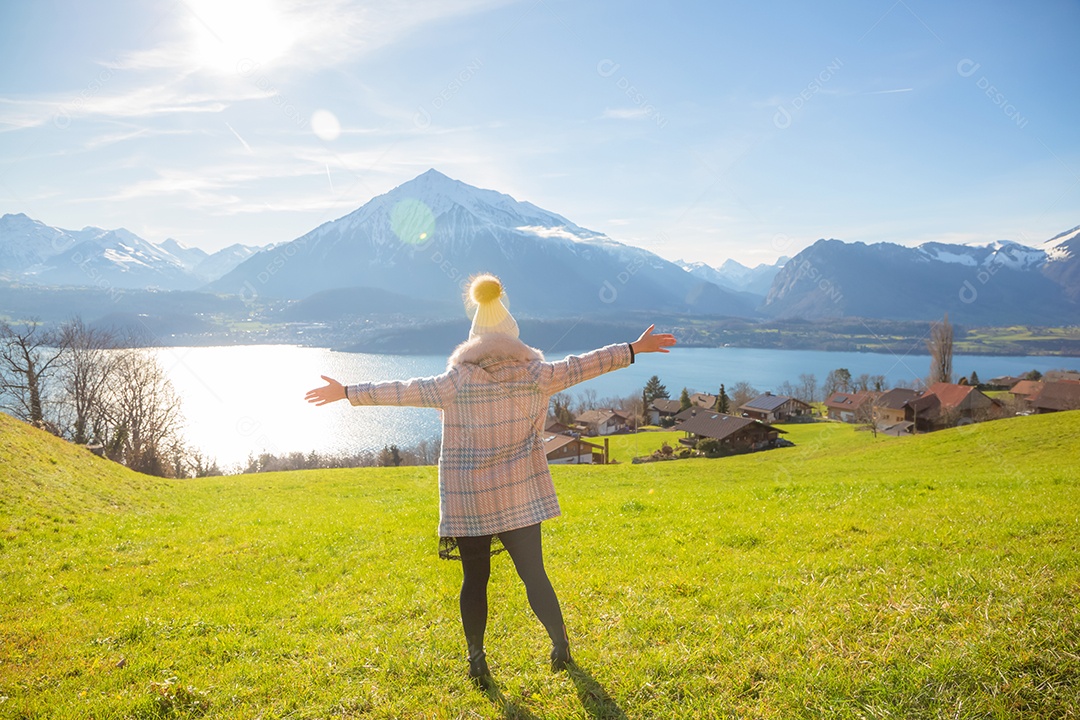 Uma foto de viagem de uma linda mulher asiática em pé, olhando feliz para o cenário natural do rio e do lago próximo à montanha durante suas férias pela manhã, o tempo está claro.