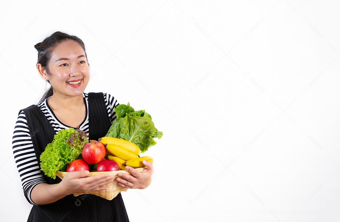 A imagem de uma linda mulher asiática segurando frutas e vegetais saudáveis ​​para dieta em fundo branco.