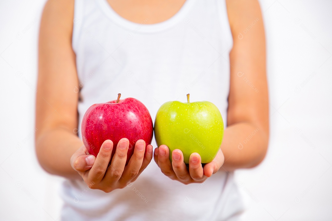 A imagem de uma criança segurando uma maçã natural vermelha e verde na mão é saudável e boa para um fundo branco.