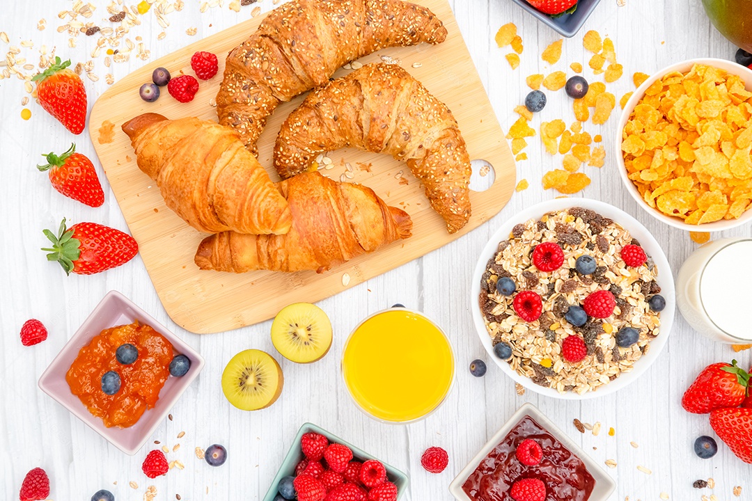 Café da manhã Servido pela manhã com croissant de manteiga e flocos de milho Grãos integrais e passas com leite em xícaras e Morango