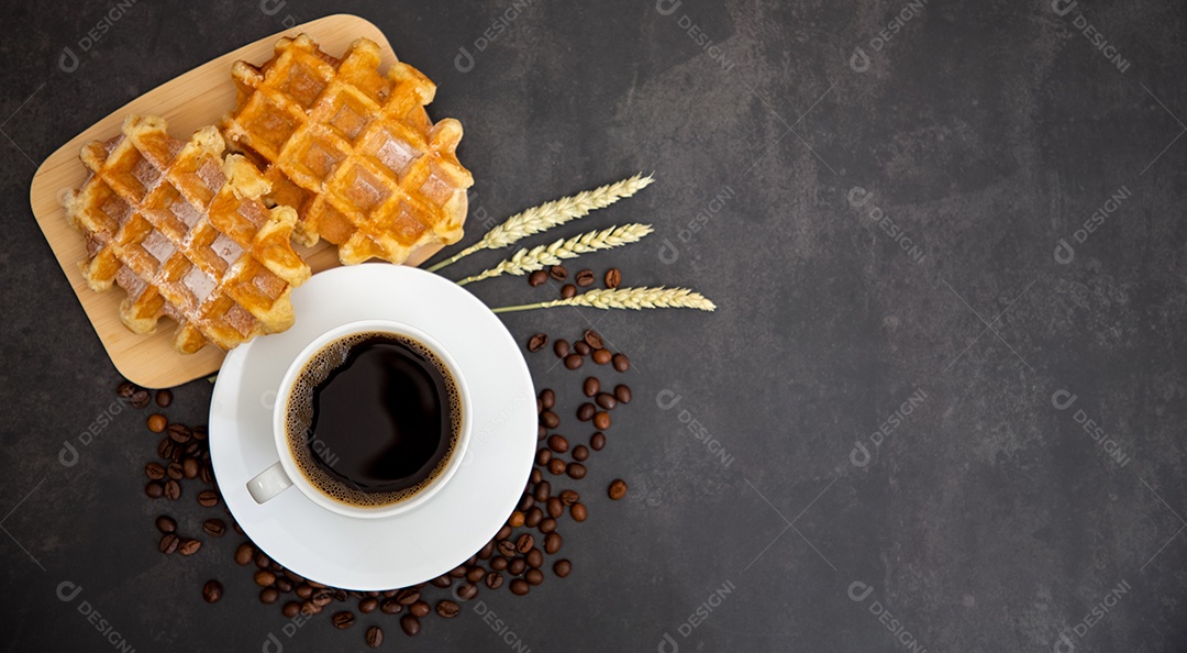 Café da manhã com uma xícara de café preto com pão com croissant e frutas na mesa de madeira.