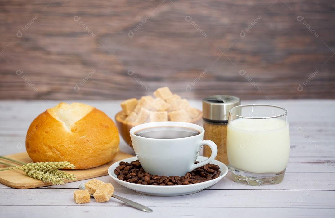 Café da manhã com uma xícara de café preto com pão com croissant e frutas na mesa de madeira.