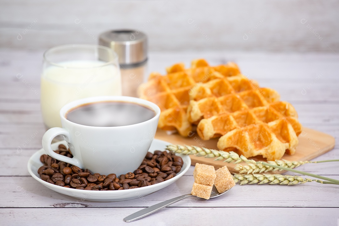 Café da manhã com uma xícara de café preto com pão com croissant e frutas na mesa de madeira.