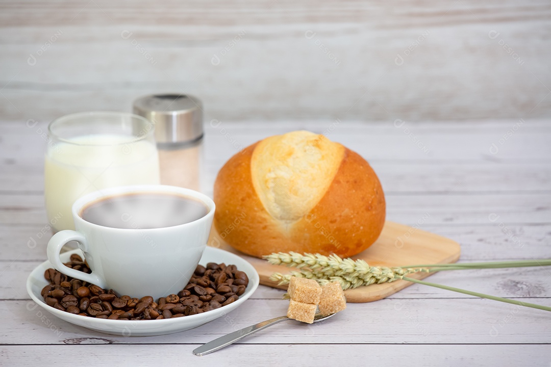 Café da manhã com uma xícara de café preto com pão com croissant e frutas na mesa de madeira.
