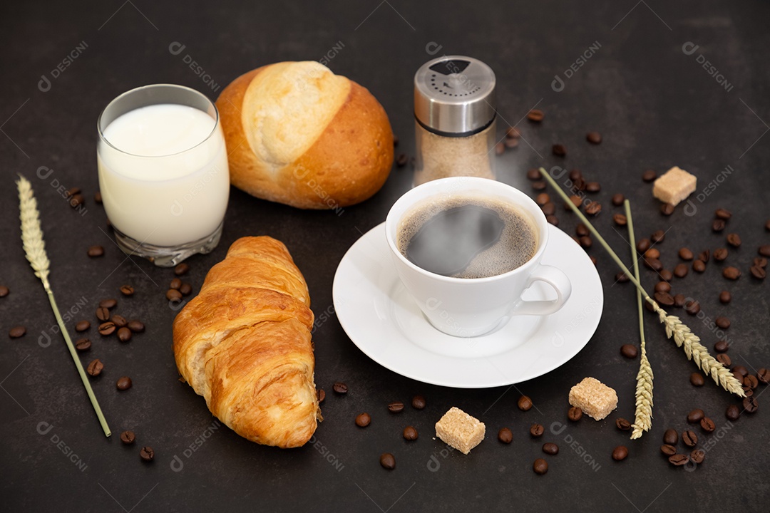 Café da manhã com uma xícara de café preto com pão com croissant e frutas no fundo preto.