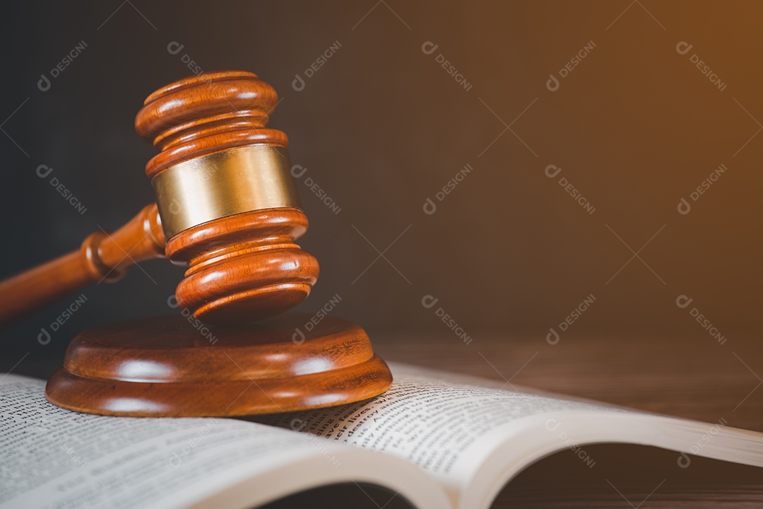 Martelo de juiz de madeira velho com livro de direito sobre o fundo de madeira da mesa, usado para julgamento e justiça