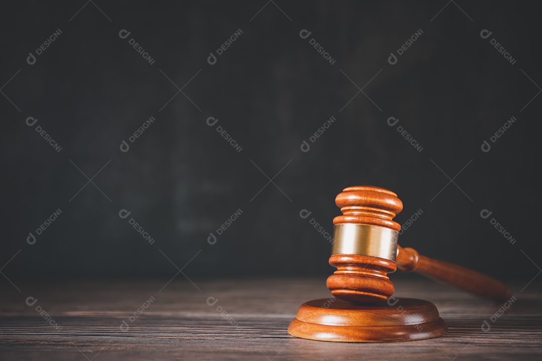 Martelo de juiz de madeira velho com livro de direito sobre o fundo de madeira da mesa, usado para julgamento e justiça