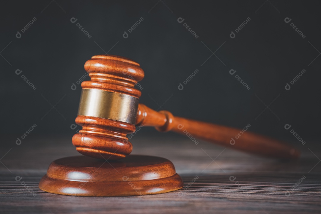 Martelo de juiz de madeira velho com livro de direito sobre o fundo de madeira da mesa, usado para julgamento e justiça