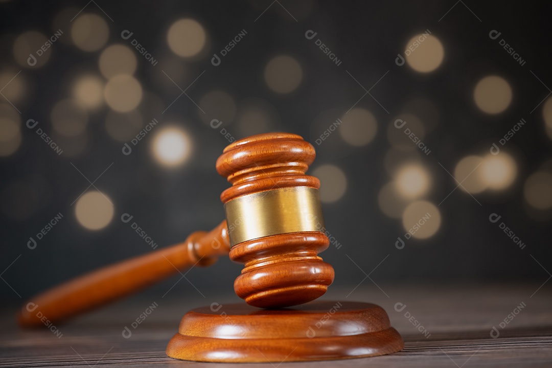 Martelo de juiz de madeira velho com livro de direito sobre o fundo de madeira da mesa, usado para julgamento e justiça