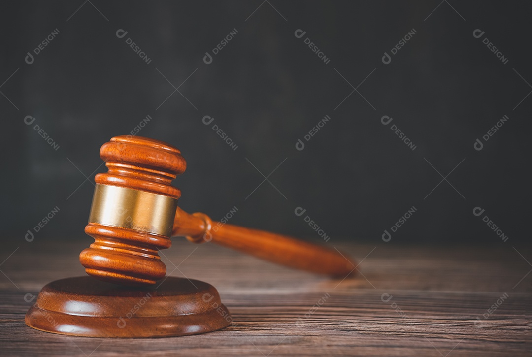 Martelo de juiz de madeira velho com livro de direito sobre o fundo de madeira da mesa, usado para julgamento e justiça.