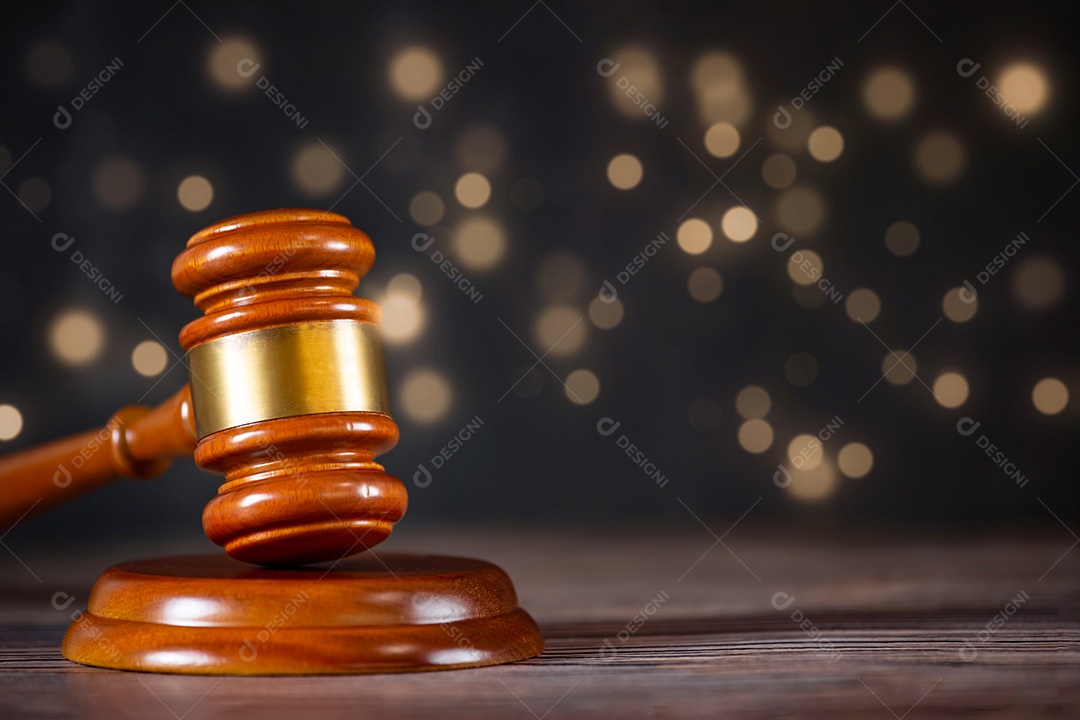 Martelo de juiz de madeira velho com livro de direito sobre o fundo de madeira da mesa, usado para julgamento e justiça