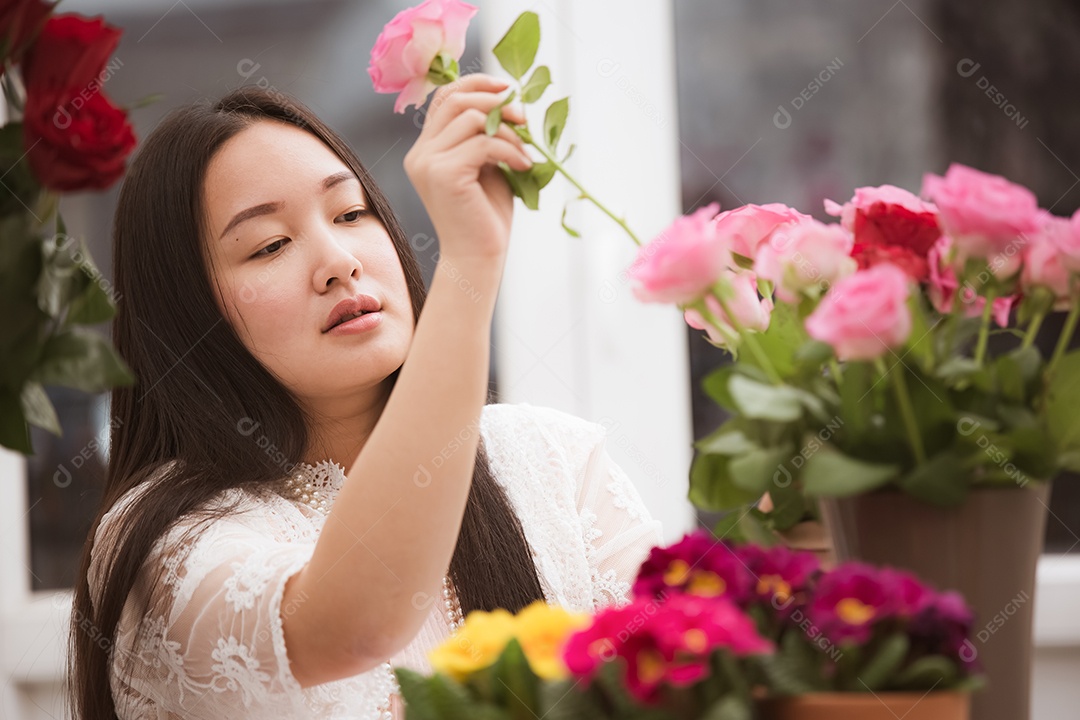 Mulher se preparando para aparar rosas vermelhas e cor de rosa e lindos arranjos de flores em casa